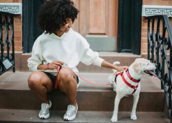 Mujer acariciando en las escaleras de casa a su perro, que la sigue a todas partes